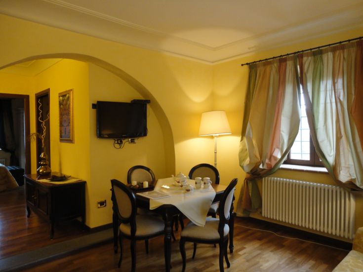 Innenansicht einer Wohnung mit einem schön gedeckten Tisch, gelben Wänden und schlichten Details.