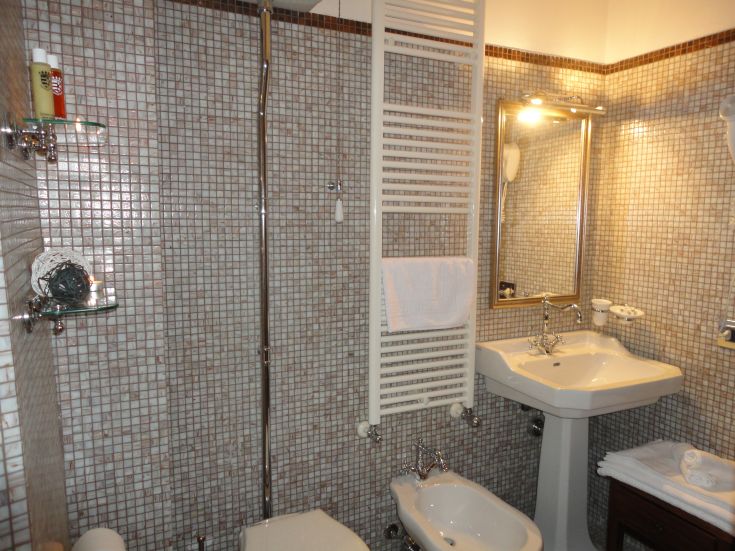 Modernes Bad mit hellen Fliesen und funktionalen Sanitäranlagen, gut beleuchtet und einladend.