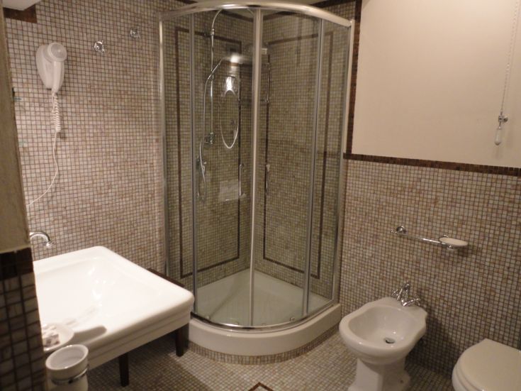  modernes Bad mit Dusche und schlichten Oberflächen, ideal für den täglichen Gebrauch.