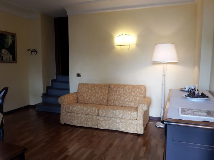 Gemütlicher Wohnbereich mit einem Sofa und einer gut beleuchteten Ecke, perfekt zum Entspannen.