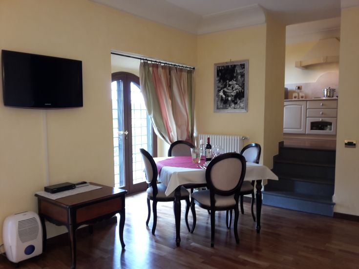 Gemütliches Wohnzimmer mit einem gedeckten Tisch und einer modernen Küchenansicht.