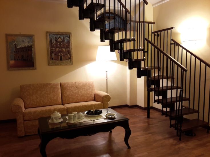 Ein schlichtes Interieur mit einer Wendeltreppe und minimalistischen Möbeln, ideal zum Entspannen.