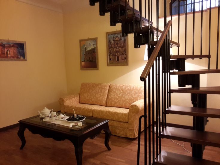 Ein einfaches und gemütliches Wohnzimmer mit einem Sofa und einem Couchtisch, perfekt zum Entspannen und geselligem Beisammensein.