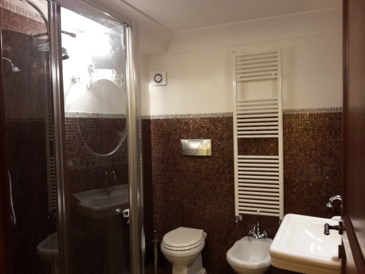 Modernes Bad mit Dusche, einfachen Sanitäranlagen und minimalistischer Ausstattung für täglichen Komfort.