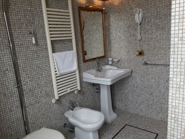 Klassisches Badezimmerdesign mit Fliesen, Waschbecken und Dusche, perfekt für Momente der Ruhe.