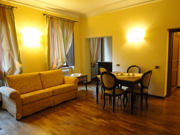 Einfaches Apartment mit einer Couch und einem Esstisch, ideal für Entspannungsmomente.