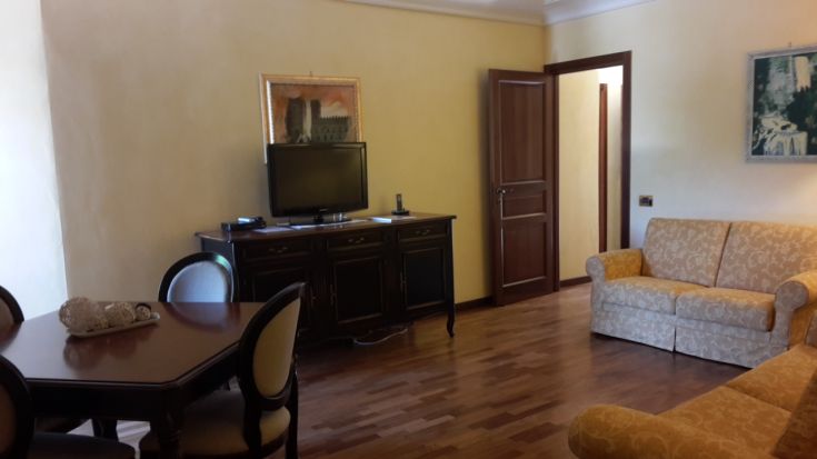 Gemütliches Wohnzimmer in einer Wohnung, mit einem Sofa und einem Fernseher, ideal zum Entspannen.