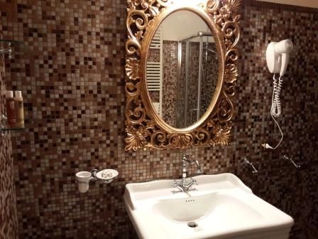 Ein einfaches Bad mit einem gerahmten Spiegel und hellen Fliesen. Ein ruhiger Ort für Ihr Wohlbefinden.