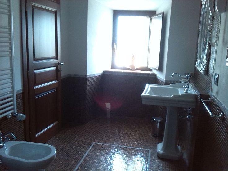 Helles Badezimmer mit modernen Ausstattungen und Ausblick auf die umliegende Landschaft.