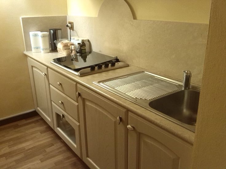 Funktionale Küche mit Kochfeld und Spüle, ideal für ruhige und gemütliche Momente.