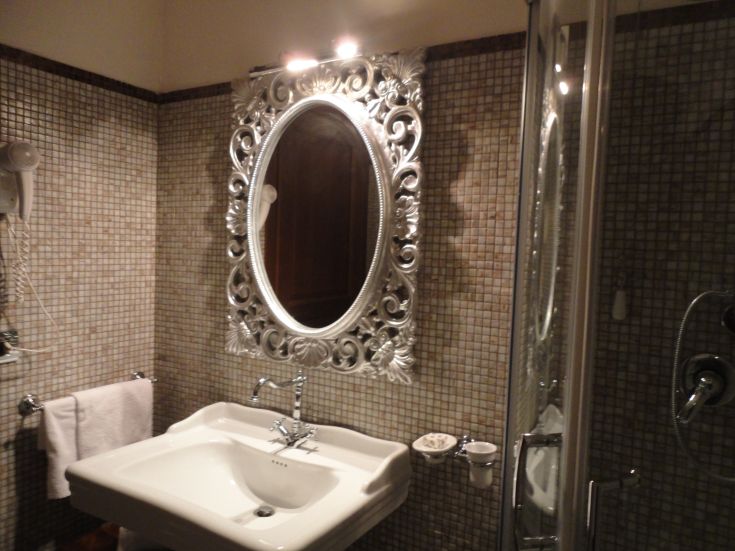 Ein einfaches Badezimmer mit Spiegel und Keramikfliesen, in einer schlichten Atmosphäre.