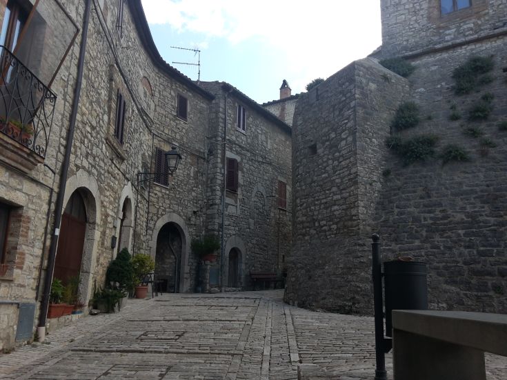 Eine charmante Gasse in einem Dorf, mit Steinhäusern und einer ruhigen Atmosphäre.