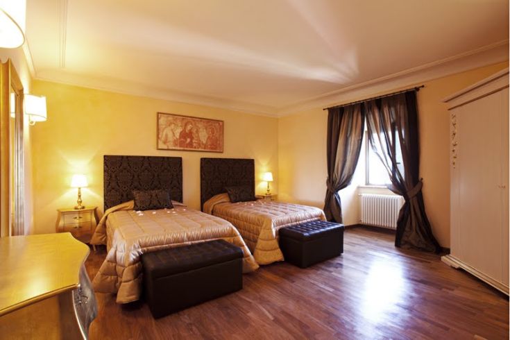 Geräumiges Zimmer mit Einzelbetten, einfachem Mobiliar und einer gemütlichen Atmosphäre für einen Aufenthalt in Ruhe.