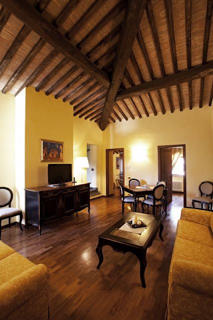 Ein gemütliches Wohnzimmer mit sichtbaren Holzbalken und schlichten Möbeln, ideal für entspannende Momente.