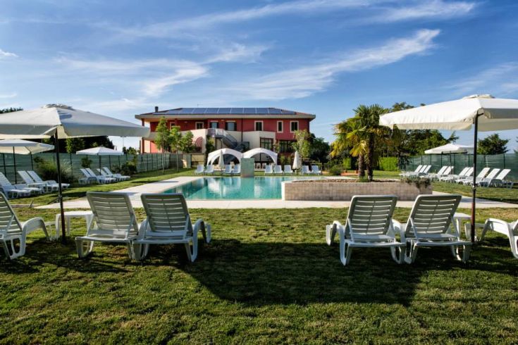 La piscine est située dans un jardin bien entretenu, idéal pour se détendre parmi les plantes et les espaces verts.