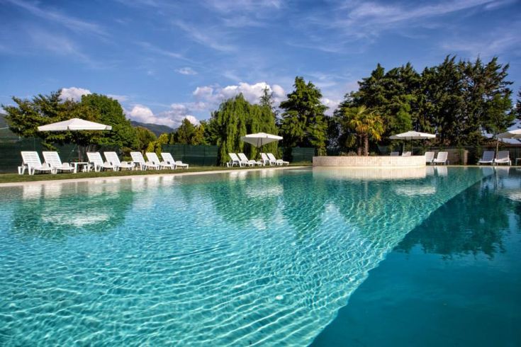 Piscine extérieure entourée de verdure luxuriante, idéale pour se détendre au soleil.