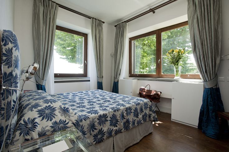 Camera semplice con panorama sulla natura, arredata con letti e decorazioni sobrie.