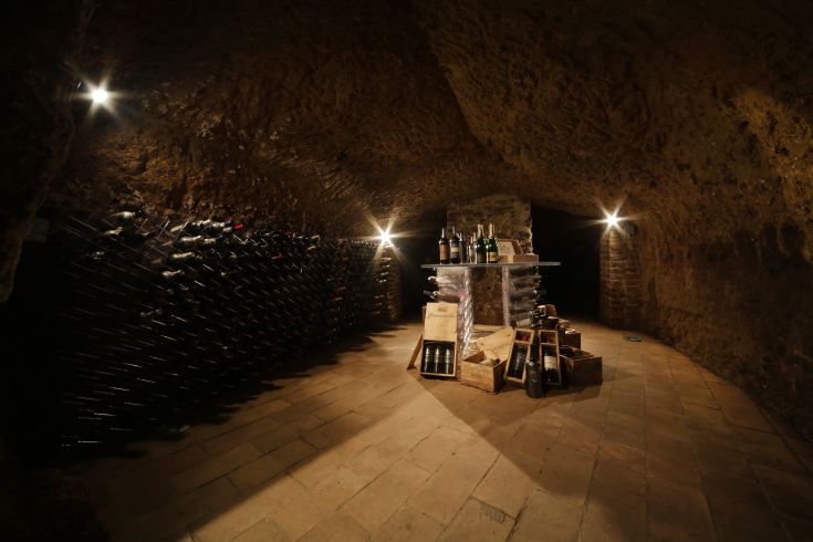 Cantina tradizionale all'interno di una grotta, con vini in esposizione e un'atmosfera accogliente.
