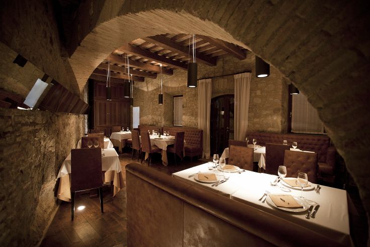 Ambiente sobrio del ristorante con pareti in pietra e arredi semplici.