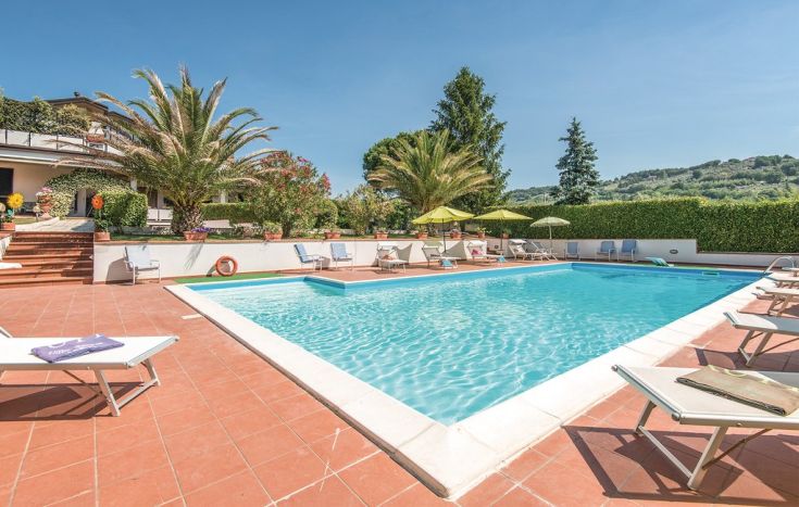 Una piscina tranquilla, circondata da palme, offre un'atmosfera rilassante e piacevole per chi vuole distendersi.