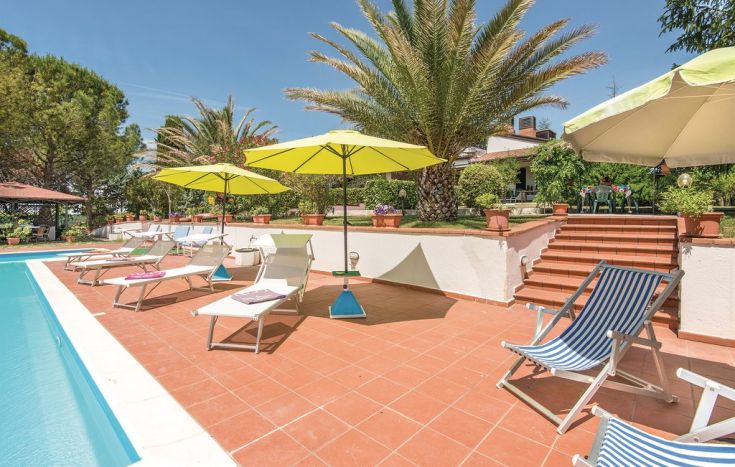 Una piscina con ombrelloni gialli e lettini ai lati. Un ambiente tranquillo per rilassarsi e apprezzare la natura circostante.