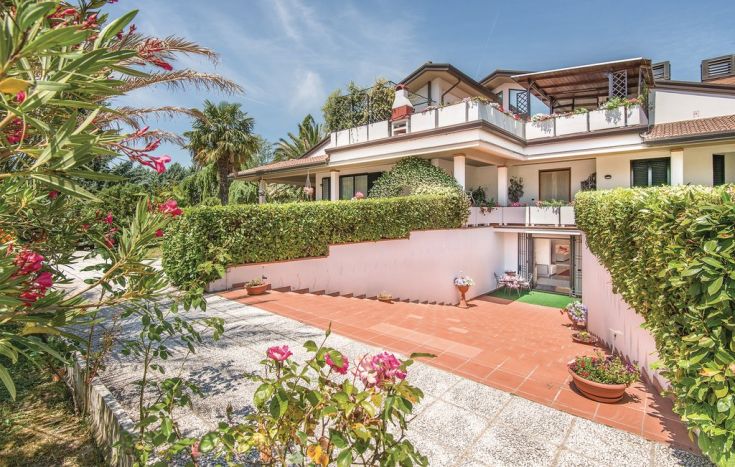 Una villa immersa nella natura, circondata da piante fiorite e un'atmosfera tranquilla.