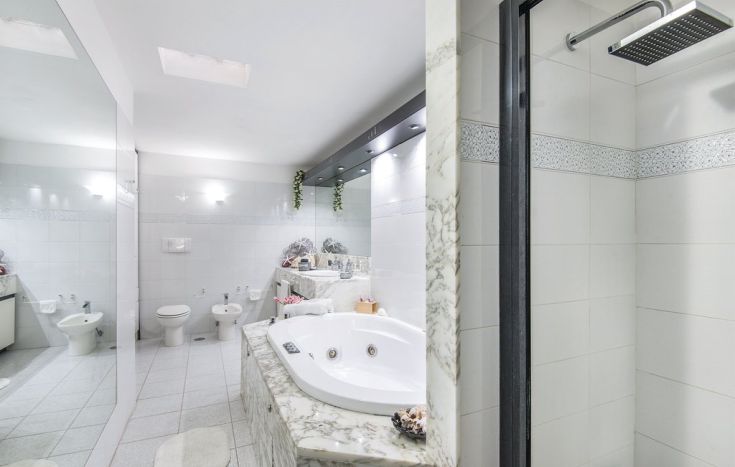 Un bagno moderno con vasca idromassaggio e doccia. Spazio luminoso e accogliente.