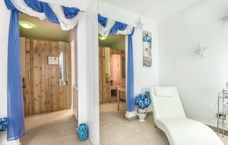 Interno sobrio e luminoso dell'area relax, caratterizzato da decorazioni blu e bianche, creando un'atmosfera tranquilla.