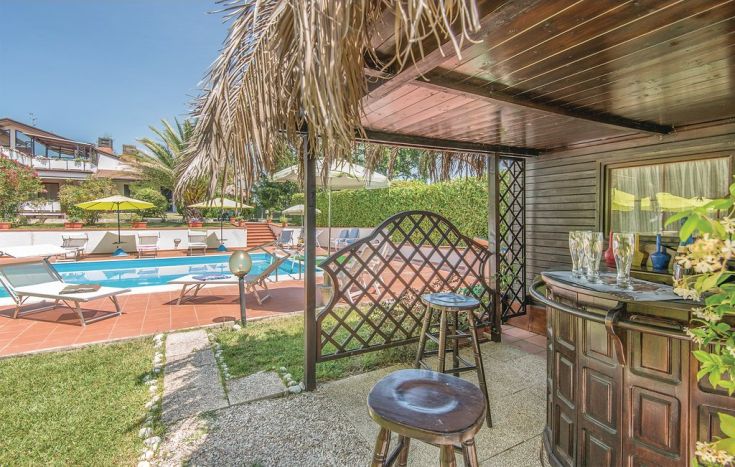 Un'area tranquilla nel giardino con una piscina circondata da piante verdi.