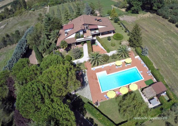 Una villa con piscina e giardino circondata dalla natura, adatta per momenti di relax.
