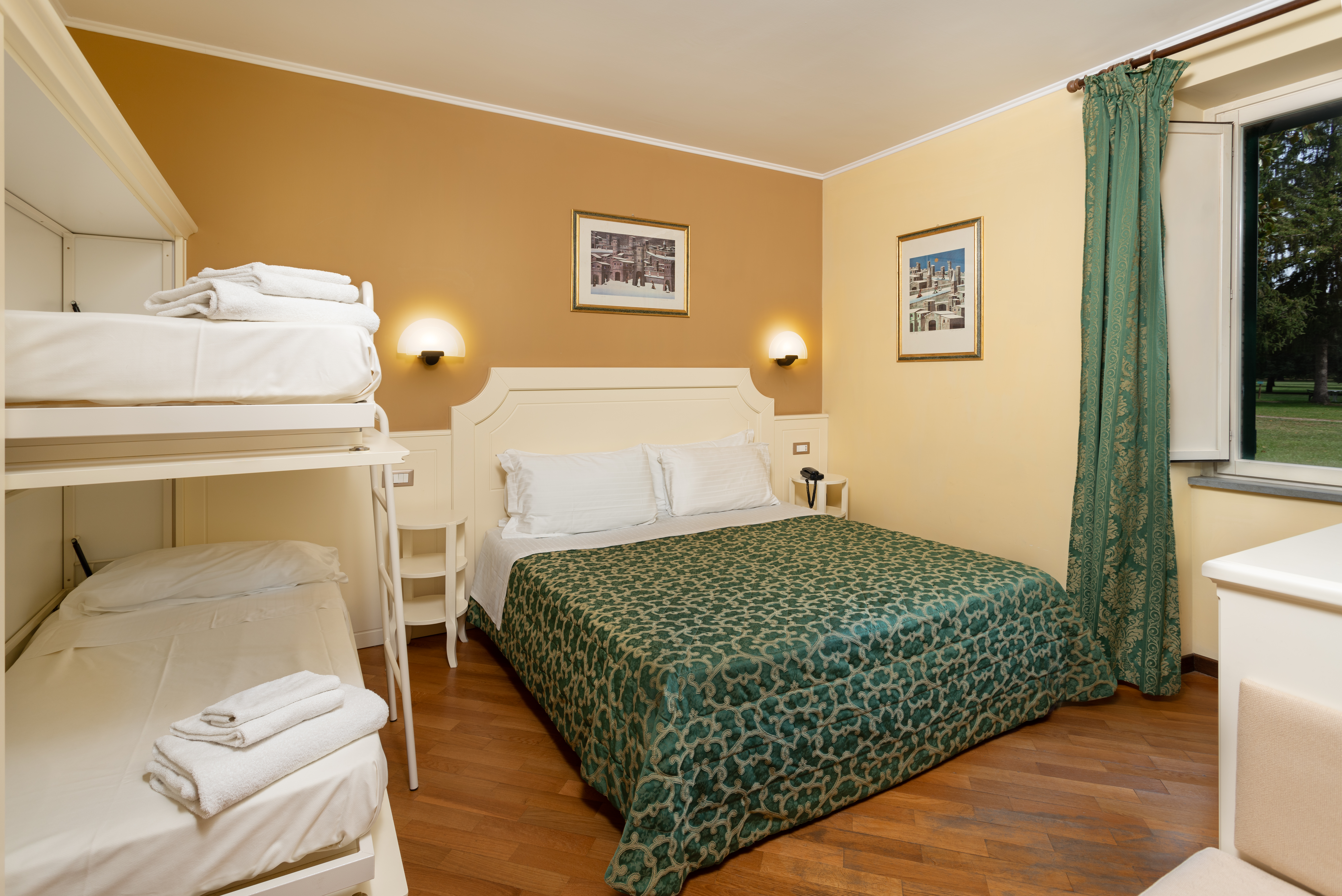 Einfaches Zimmer mit einem Doppelbett und Etagenbetten, ideal für Familien.