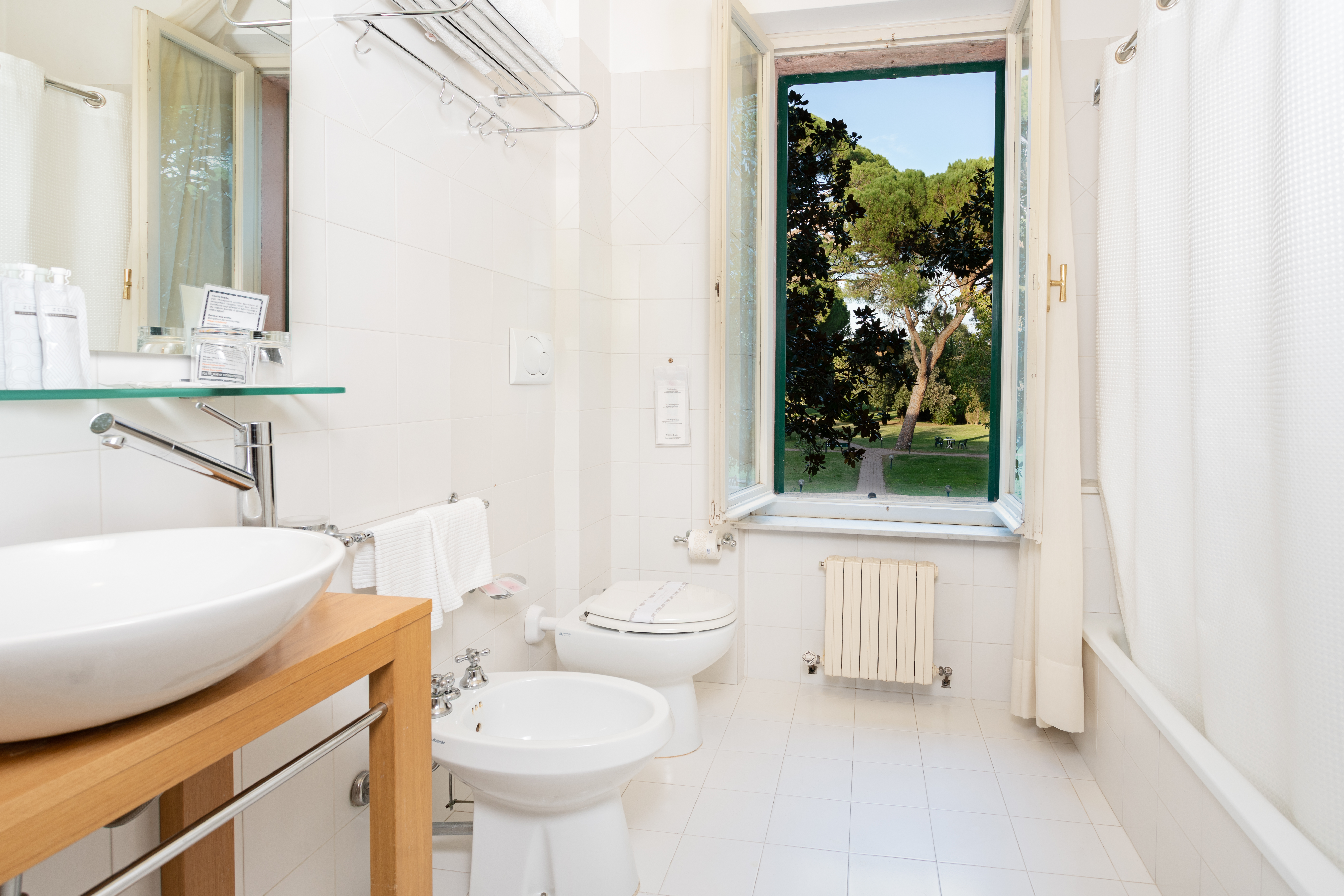 Ein einladendes Badezimmer mit Blick auf einen grünen Park, ideal für entspannende Momente.