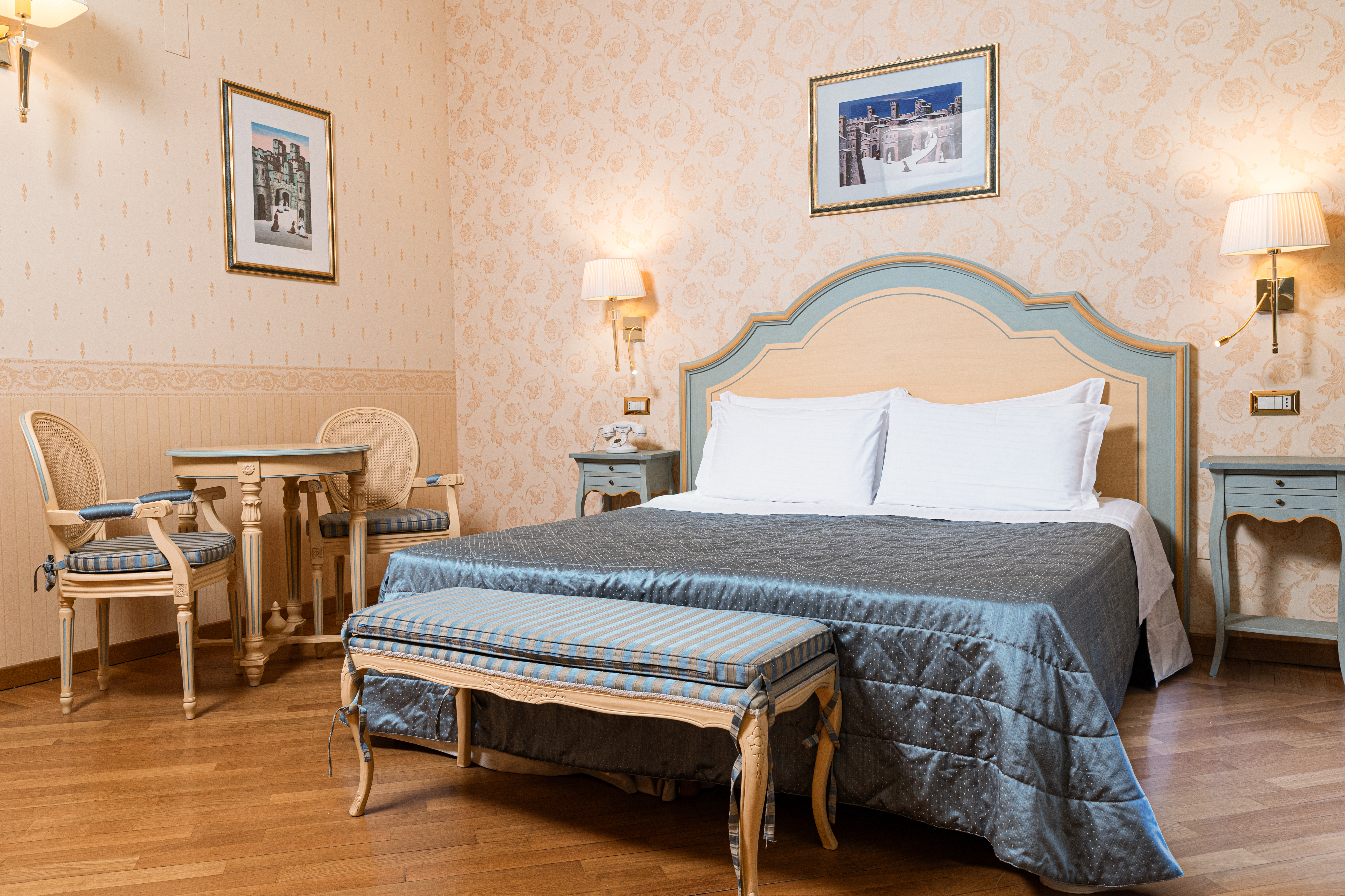 Einfaches und helles Zimmer im Palazzo San Clemente, ausgestattet mit funktionalen Möbeln für einen ruhigen Aufenthalt.