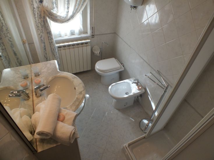 Interno sobrio di un bagno con lavabo in marmo e asciugamani riposti ordinatamente.