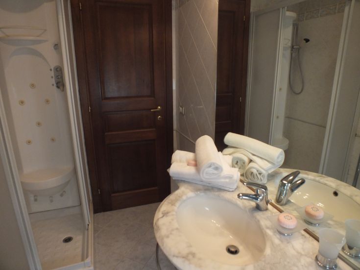 Un bagno funzionale con doccia moderna e asciugamani sistemati con cura. Atmosfera tranquilla.