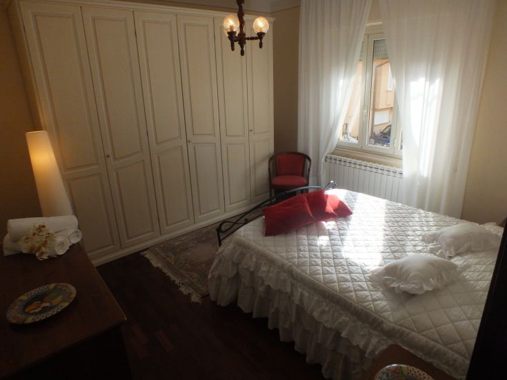 Camera da letto confortevole con armadi bianchi e abbondante luce naturale, luogo ideale per rilassarsi.