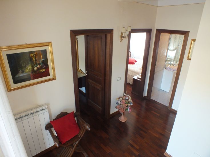 Un corridoio accogliente di un appartamento con porte che conducono a diverse stanze.