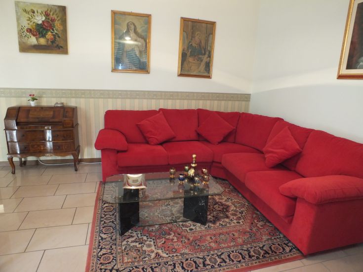 Un soggiorno accogliente con un divano rosso e decorazioni sulle pareti.