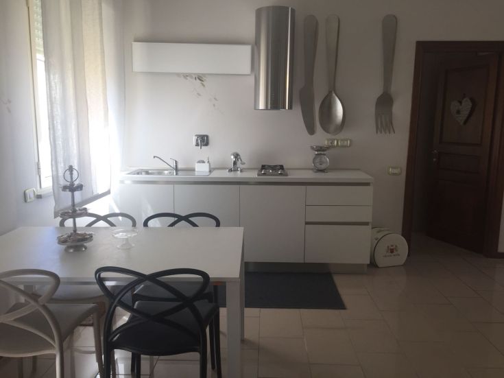 Una cucina moderna luminosa con un tavolo da pranzo e decorazioni originali.