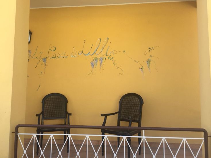 Un angolo confortevole con sedie, una decorazione murale e il nome 