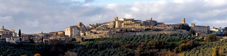 Panorama di un borgo storico circondato da spazi verdi e natura.