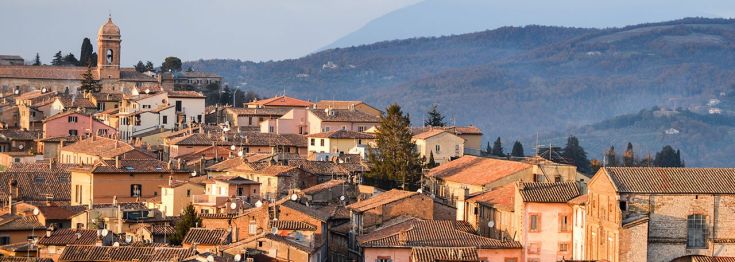 Panorama della città con case colorate e colline nei dintorni, creando un'atmosfera tranquilla.