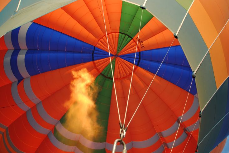 Interno di una mongolfiera colorata durante il decollo.