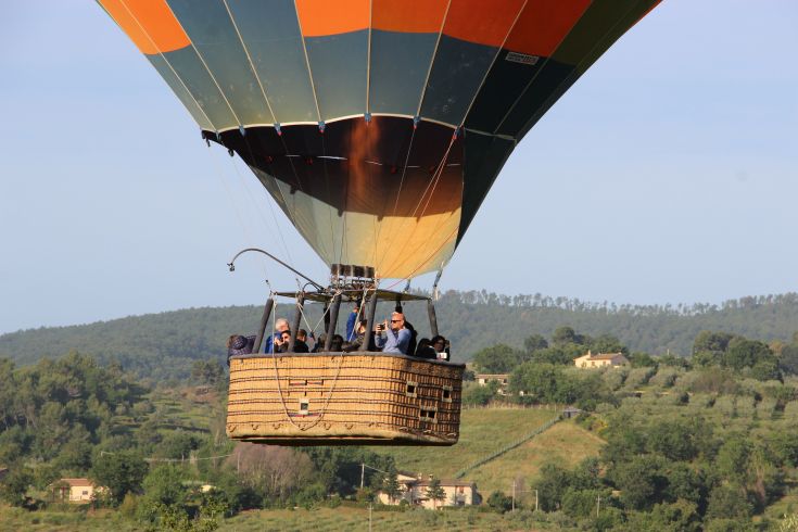 Un volo in mongolfiera sopra dolci colline verdi, ideale per ammirare il paesaggio naturale circostante.