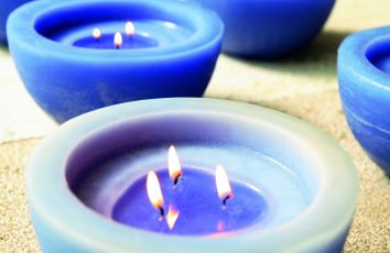 Candele blu accese che producono una luce calda, ideali per dare un tocco di relax all'ambiente.