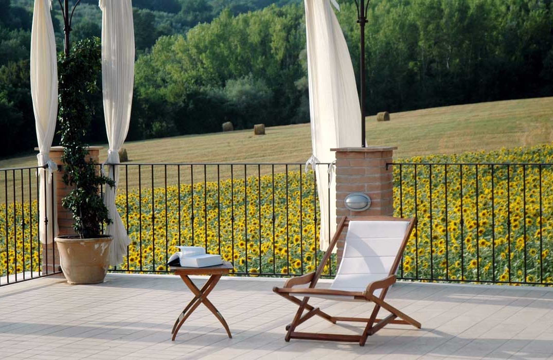 Una comoda sedia a sdraio su un terrazzo, immersa in un ambiente di girasoli.