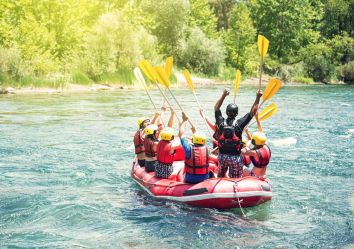 Un gruppo di persone partecipa a un'escursione di rafting divertente su un fiume tranquillo.