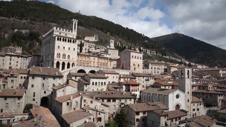 Un panorama di un borgo umbro con edifici storici e un'atmosfera tranquilla.