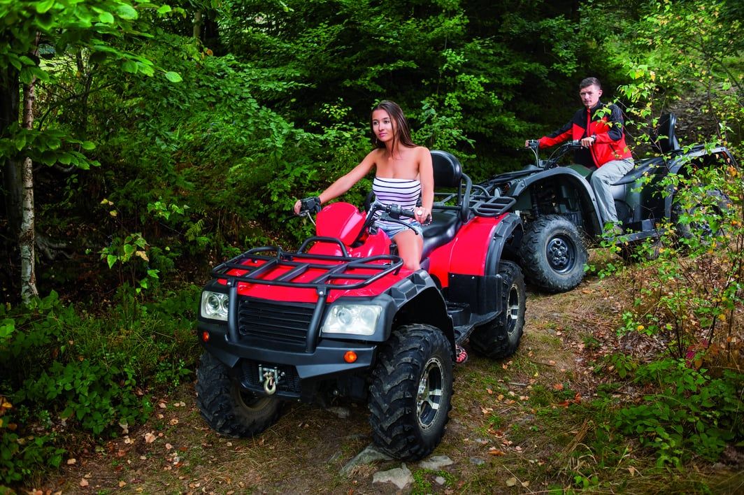 Due amici si divertono a esplorare un sentiero immerso nel verde su un ATV.