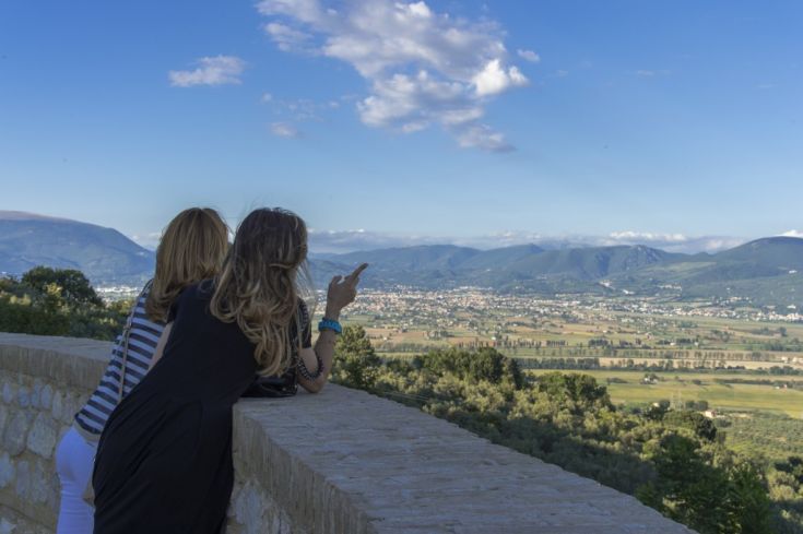 Due persone osservano un panorama naturale, immersi nella tranquillità del paesaggio umbro.
